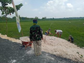 Anggota Satgas TMMD Bojonegoro Bersama Warga Timbun Sisi Jalan aspal Gunakan Katel